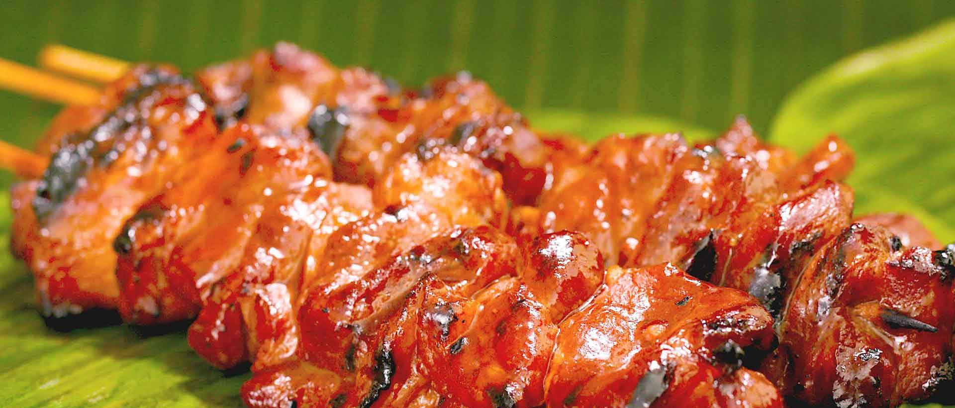 Skewers of Filipino pork barbecue grilled over charcoal at House of Grill